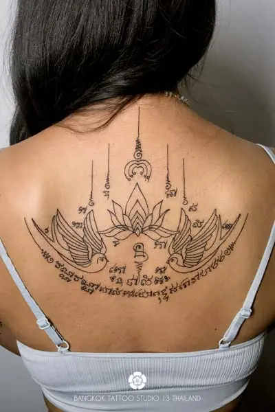 sak-yant-twin-birds-lotus-tattoo-modern-woman